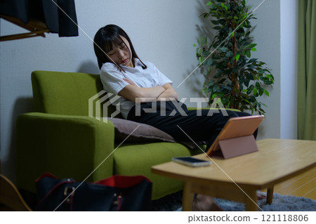 一個獨居的女人在看平板電腦時睡著了。 一個獨居的女人在看平板電腦時睡著了。 121118806