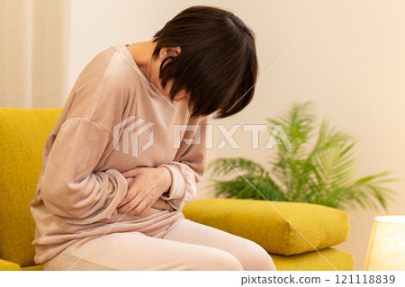 冬夜客廳裡腹痛的中老年婦女 121118839