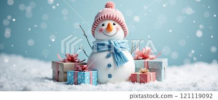 Snowman is happy with his present on Christmas Day with falling snow and soft lights behind. 22:9 wide viewing angle. 121119092