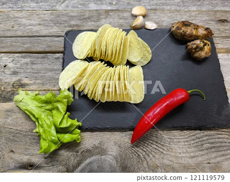 crispy potato chips on a sliced board crispy potato chips on a sliced board 121119579