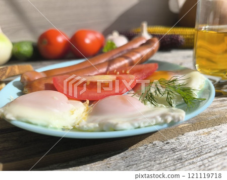 Golden baked potatoes with sausages on a white plate. High-quality photos 121119718