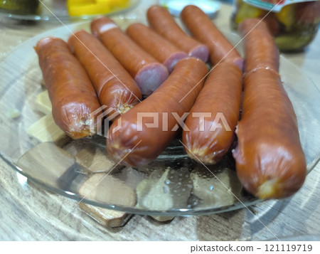 Golden baked potatoes with sausages on a white plate. High-quality photos 121119719