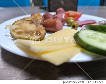 Golden baked potatoes with sausages on a white plate. High-quality photos Golden baked potatoes with sausages on a white plate. High-quality photos 121119721