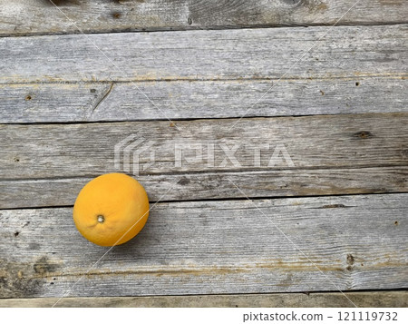 simple wooden table with a single ripe orange, top view. simple wooden table with a single ripe orange, top view. 121119732
