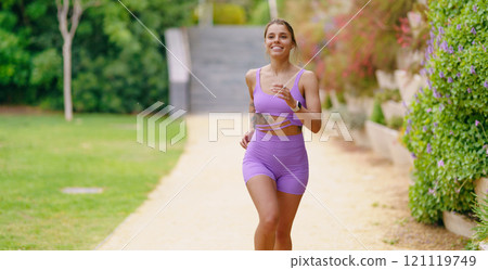 A Vibrant and Active Woman Enjoying a Refreshing Jogging Session in a Beautiful Park Setting 121119749