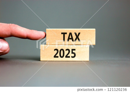 Planning tax 2025 new year symbol. Concept words Tax 2025 on beautiful wooden blocks. Beautiful grey background. Businessman hand. Business tax 2025 new year concept. Copy space. 121120236