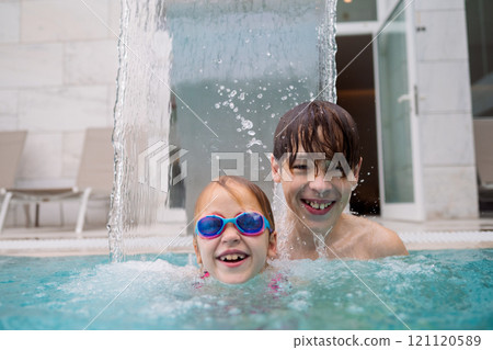 Kids smiling in pool water Kids smiling in pool water 121120589