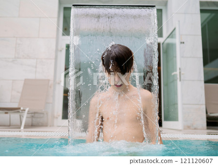 Teen boy enjoying water stream Teen boy enjoying water stream 121120607