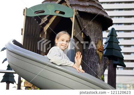 Happy young girl. Child on playground. Kids play outdoors.  121120623