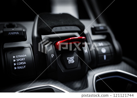 The image captures the central console of a Lamborghini Urus Performante, featuring a red flip cover over the Start Engine Stop button and drive mode selector. 121121744