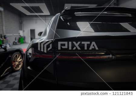 The image features the rear section of a Lamborghini Urus Performante, highlighting its aerodynamic design and taillights, with a McLaren 720S in the background. The image features the rear section of a Lamborghini Urus Performante, highlighting its aerodynamic design and taillights, with a McLaren 720S in the background. 121121843