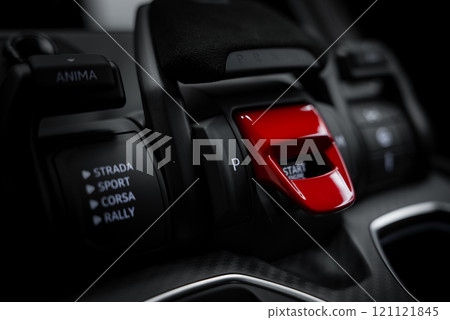 Interior view of a Lamborghini Urus Performante featuring a red start or stop button and driving mode selectors labeled Strada, Sport, Corsa, and Rally. Interior view of a Lamborghini Urus Performante featuring a red start or stop button and driving mode selectors labeled Strada, Sport, Corsa, and Rally. 121121845