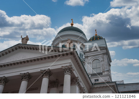 Helsinki Cathedral in Finland features a white facade, grand columns, and a green dome with a golden cross. Statues of apostles adorn the roof. Helsinki Cathedral in Finland features a white facade, grand columns, and a green dome with a golden cross. Statues of apostles adorn the roof. 121121846