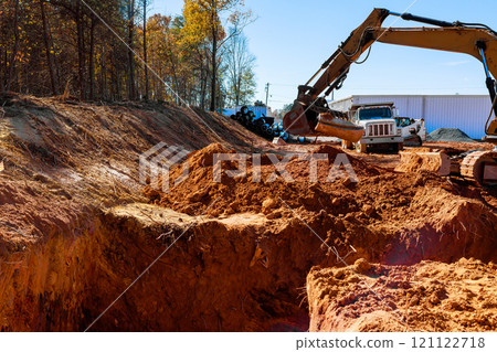 Heavy excavator is moving, excavating dirt at construction site during excavation work Heavy excavator is moving, excavating dirt at construction site during excavation work 121122718