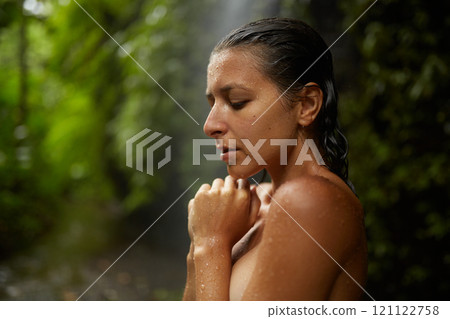 Portrait of a young slender nude woman near an incredibly beautiful waterfall in a cliff in the jungle on the popular island of Bali. Portrait of a young slender nude woman near an incredibly beautiful waterfall in a cliff in the jungle on the popular island of Bali. 121122758