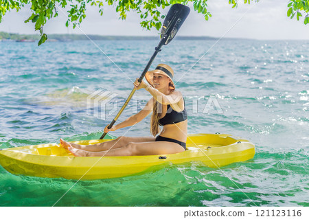 Woman kayaking on Bacalar Lake in Mexico. Adventure tourism in Quintana Roo, outdoor exploration, and water activities concept Woman kayaking on Bacalar Lake in Mexico. Adventure tourism in Quintana Roo, outdoor exploration, and water activities concept 121123116