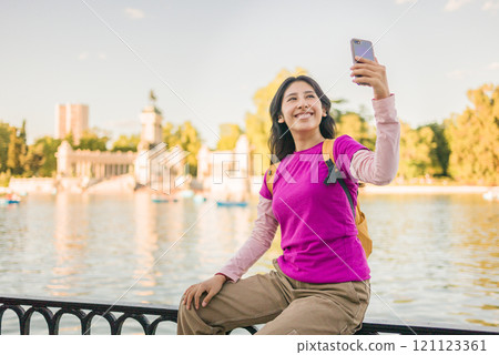 Young peruvian woman taking selfie in retiro park, madrid 121123361