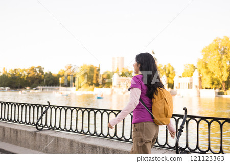 Young latin american woman exploring retiro park in madrid 121123363