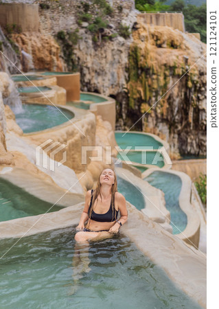 Female tourist at the hot springs of Grutas Tolantongo, Mexico. Adventure, relaxation, and natural wellness concept Female tourist at the hot springs of Grutas Tolantongo, Mexico. Adventure, relaxation, and natural wellness concept 121124101