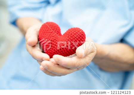 Asian elder senior woman patient holding red heart in hospital. Asian elder senior woman patient holding red heart in hospital. 121124123
