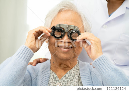 Optometrist checking Asian elderly woman ophthalmic vision eye test and using optical trial frame. 121124124