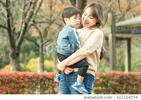 Parents and children (boy and mother) walking in an autumn park Parents and children (boy and mother) walking in an autumn park 121124374