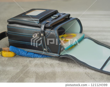 An open school bag (on the carpet) An open school bag (on the carpet) 121124399