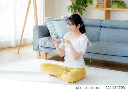 在房間裡操作智慧型手機的年輕女子 121124703