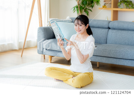 在房間裡操作智慧型手機的年輕女子 121124704