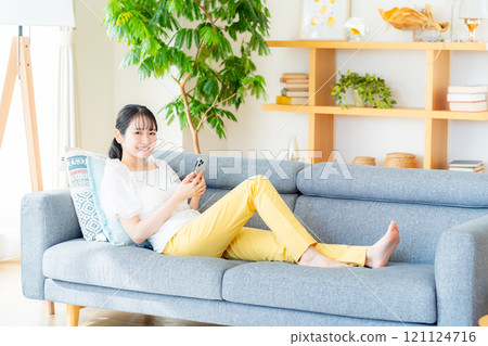 在房間裡操作智慧型手機的年輕女子 121124716