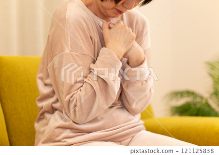 冬夜,中高級女性在客廳感到寒冷 冬夜,中高級女性在客廳感到寒冷 121125838