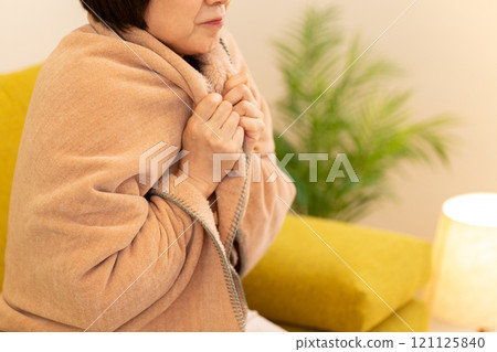 冬夜,中高級女性在客廳感到寒冷 冬夜,中高級女性在客廳感到寒冷 121125840