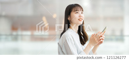 Smiling young woman/businesswoman holding a smartphone 121126277