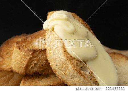 Spread melted cheese on baguette Spread melted cheese on baguette 121126531