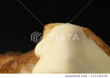 Spread melted cheese on baguette 121126534