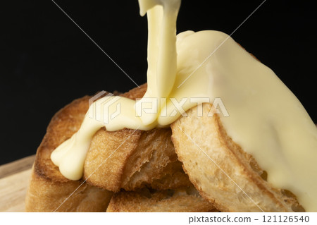 Spread melted cheese on baguette Spread melted cheese on baguette 121126540