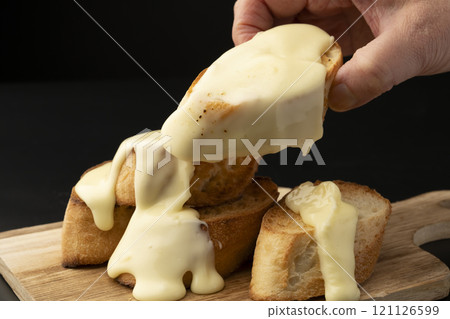 拿起一個覆蓋著起司的法國麵包 121126599
