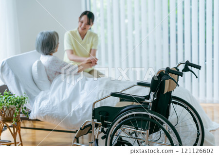住在療養院的一名老年婦女和一名年輕護理人員 121126602