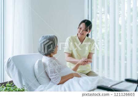 住在療養院的一名老年婦女和一名年輕護理人員 121126603