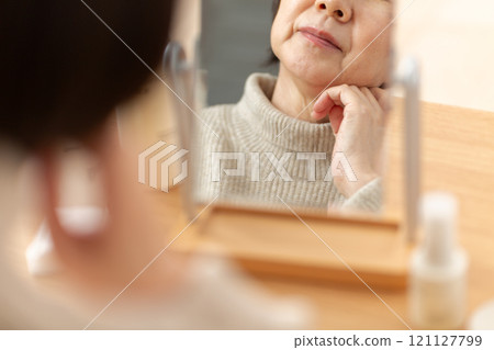 中高級女性在鏡子前擔心皮膚護理 121127799