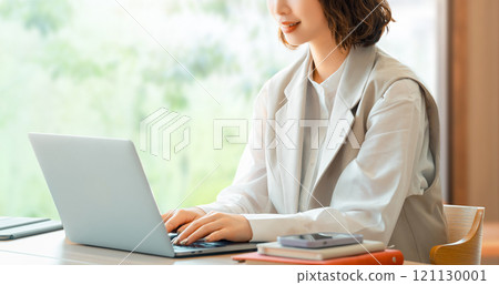 一位微笑的女商人在辦公桌前使用筆記型電腦工作 一位微笑的女商人在辦公桌前使用筆記型電腦工作 121130001