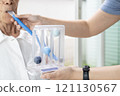 Asian female caregiver holding spirometer,taking care of senior grandmother at nursing home,elderly using spirometer,exercise the lung,help the lung expansion,concept of service,medical,health care 121130567