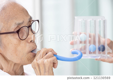 Asian senior woman using incentive spirometer,check her lung,pulmonary function test,measuring the air capacity of lungs,breathing,taking air into and expelling it from the lungs,healthcare,medical 121130569