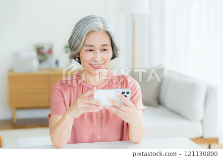 在客廳裡操作智能手機的女高管 121130800