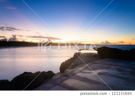 Sunrise seen from the beach at Toguchi Beach 121131693