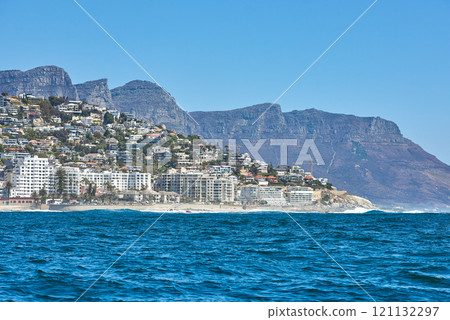 Scenic view of sea and blue sky at Camps Bay beach with the Twelve Apostles mountains in the background. Peaceful seascape ocean with copy space and building infrastructure in Cape Town, South Africa Scenic view of sea and blue sky at Camps Bay beach with the Twelve Apostles mountains in the background. Peaceful seascape ocean with copy space and building infrastructure in Cape Town, South Africa 121132297