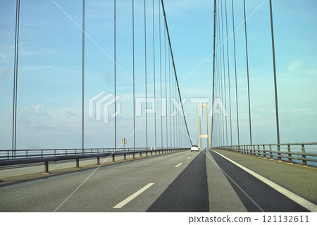 Storebaelt suspension bridge in Denmark against blue sky background. Overpass road crossing for transport to link travel destination routes. Infrastructure and architecture design of famous landmark Storebaelt suspension bridge in Denmark against blue sky background. Overpass road crossing for transport to link travel destination routes. Infrastructure and architecture design of famous landmark 121132611