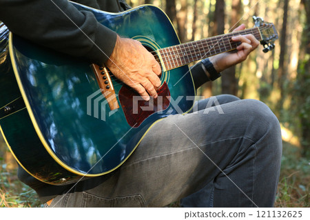 Close-up of a man's hands playing acoustic guitar 121132625
