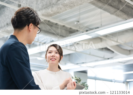 Businessmen and businesswomen working in free-address offices 121133014