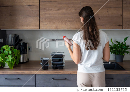 Young woman with healthy diet plan for weight loss, delivery of daily ready meal menu. Woman using meal tracker app on phone. Balanced portion with dish. Pre-cooking. 121133735